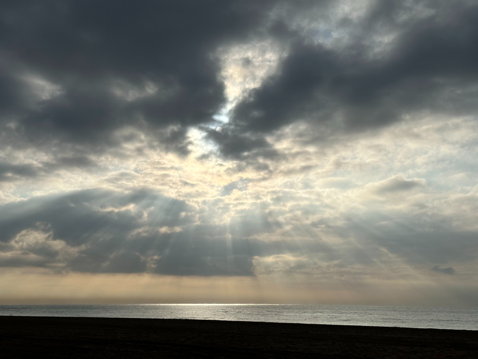 Sunlight breaking through storm clouds over the sea