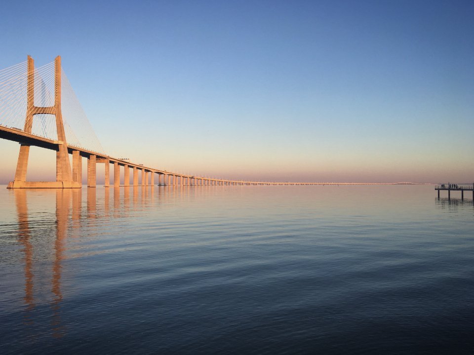 A long bridge stretching across the water at sunset