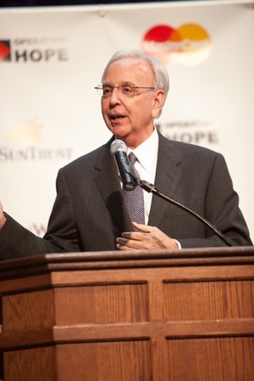 Jim Wells speaking at a podium at an Operation HOPE event