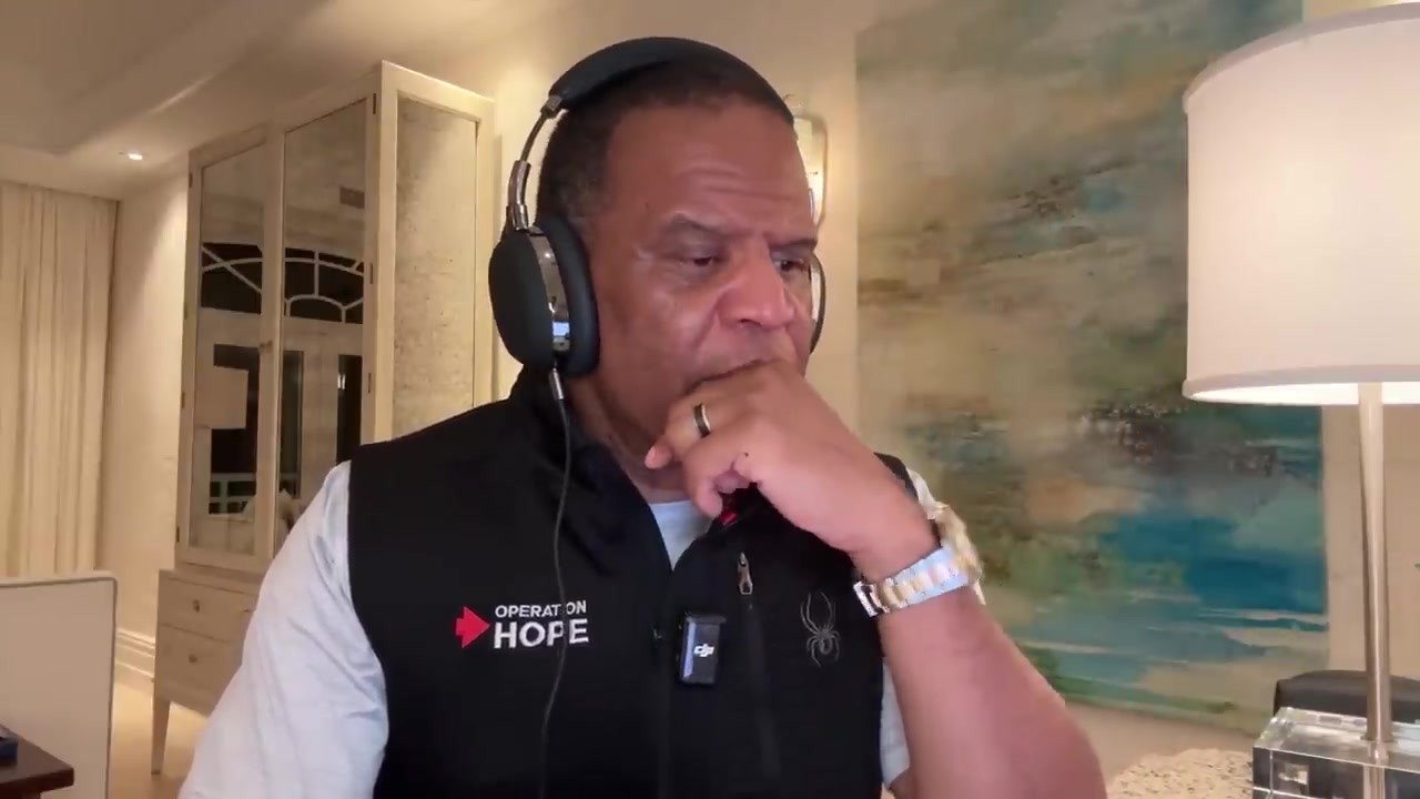 John Hope Bryant wearing headphones during a radio interview